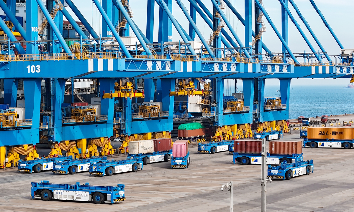 Automated guided vehicles handle containers at a fully automated container dock in Qingdao Port, East China's Shandong Province on December 23, 2024. Chinese ports are expected to complete cargo throughput of 17.5 billion tons in 2024, up 3.4 percent year-on-year, according to China's Ministry of Transport on Monday.