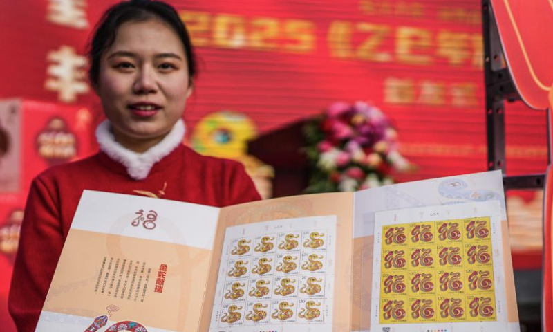 A staff member shows special stamps marking the Year of the Snake in Guiyang, southwest China's Guizhou Province, Jan. 5, 2025. China Post on Sunday unveiled a set of two special stamps to celebrate the upcoming Chinese zodiac Year of the Snake. (Xinhua/Tao Liang)