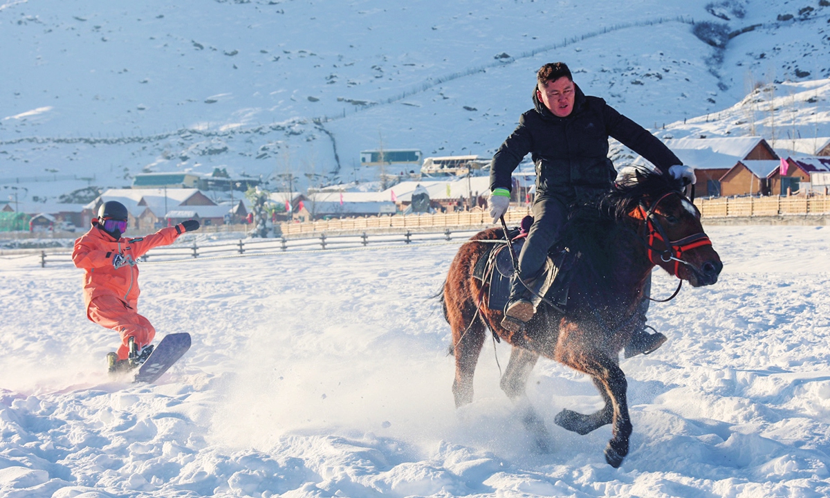 A tourist enjoys horse-drawn snowboarding in Altay, Northwest China's Xinjiang Uygur Autonomous Region. Photo: VCG