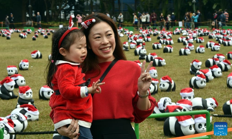 People pose for photos with giant panda sculptures at Sun Yat Sen Memorial Park in Hong Kong, south China on Dec. 25, 2024. A theme exhibition featuring 2,500 giant panda sculptures was held here on Wednesday. (Xinhua/Lo Ping Fai)