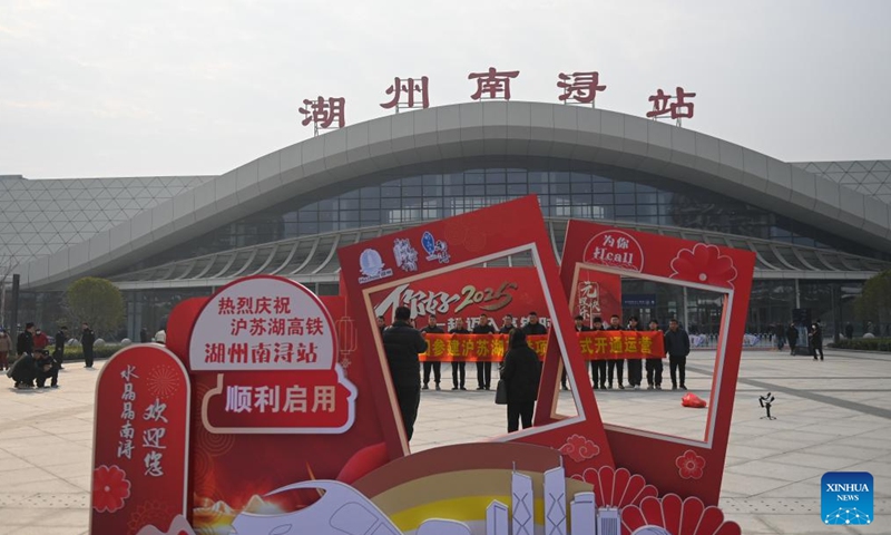 Representatives of constructors celebrate the operation of the Shanghai-Suzhou-Huzhou high-speed railway at the Huzhou Nanxun Railway Station in Huzhou, east China's Zhejiang Province, Dec. 26, 2024.