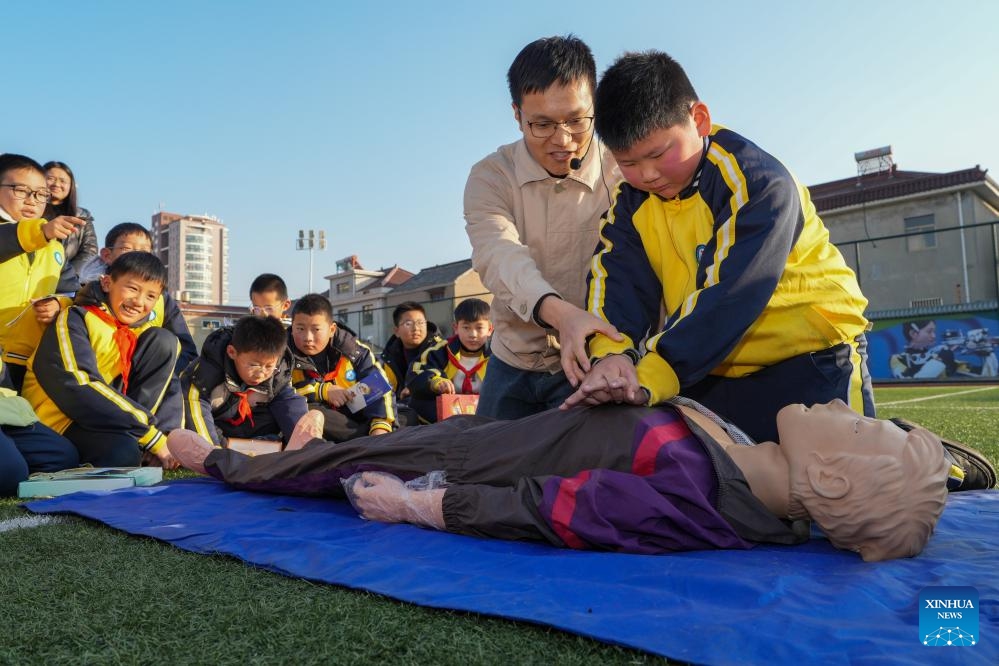 Students participate in a first aid drill for an electric shock during a safety education session in Yangzhou, east China's Jiangsu Province, Dec. 26, 2024. Several departments in Yangzhou jointly carried out safety education and publicity activities for primary and secondary school students, enhancing their safety awareness and improving their safety prevention skills. (Xinhua/Li Bo)