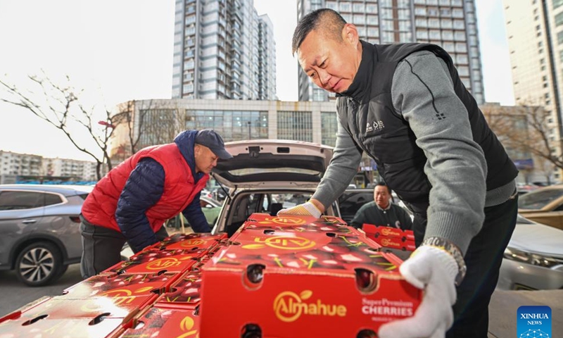 Staff members of a supermarket carry Chilean cherries in Xiqing District of Tianjin, north China, Dec. 26, 2024.