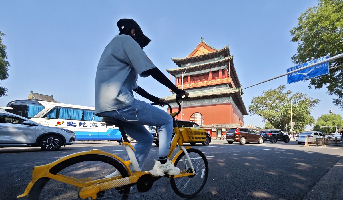 A tourist rides a shared bike along the Beijing Central Axis. Photo: VCG