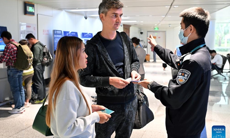 Tourists from Singapore consult a staff member on immigration clearance issues at the Meilan International Airport in Haikou, south China's Hainan Province, Dec. 28, 2024.