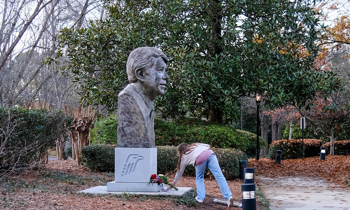 A person leaves flowers in front of a bust of former US president Jimmy Carter at the Carter Presidential Center in Atlanta, Georgia, on December 29, 2024. Photo: VCG