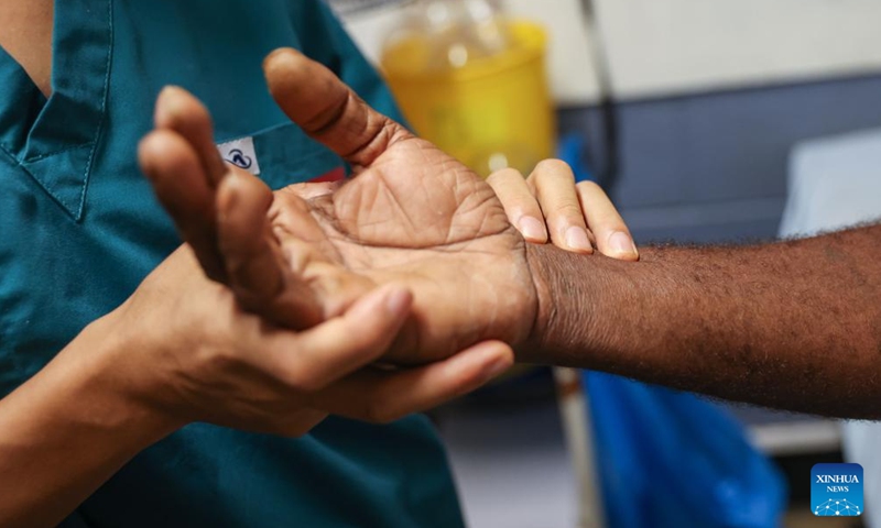 Xie Henghui, an acupuncturist of Chinese medical team, feels a patient's pulse at Vila Central, the main hospital in Port Vila, Vanuatu, on Jan. 2, 2025. Members of the third batch of Chinese medical team to Vanuatu have rendered professional service to more than 1,800 patients since they were deployed in the Pacific Island nation in September 2024.