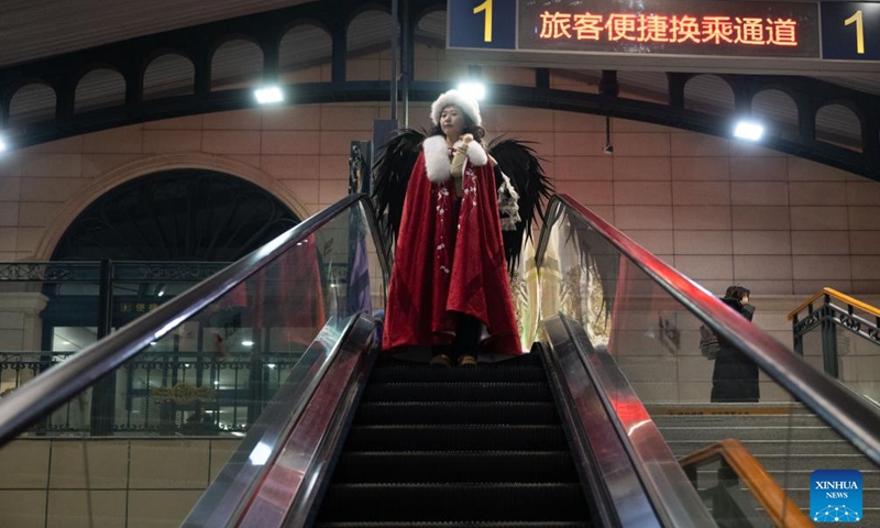 A dressed-up passenger prepares for photo shooting at the Harbin Railway Station in Harbin, capital of northeast China's Heilongjiang Province, Jan. 2, 2025. The train K5197 from Harbin to Yabuli South of northeast China's Heilongjiang Province, the first train themed on ice and snow tourism under the China Railway Harbin Group, started operation on Thursday. Passengers can experience photo taking in cabinets with different themes. (Xinhua/Zhang Tao)