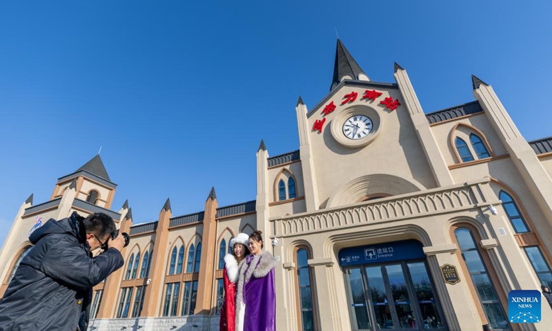 Passengers pose for photos at the Yabuli South Railway Station in Yabuli Town of Shangzhi City, northeast China's Heilongjiang Province, Jan. 2, 2025. The train K5197 from Harbin to Yabuli South of northeast China's Heilongjiang Province, the first train themed on ice and snow tourism under the China Railway Harbin Group, started operation on Thursday. Passengers can experience photo taking in cabinets with different themes. (Xinhua/Zhang Tao)