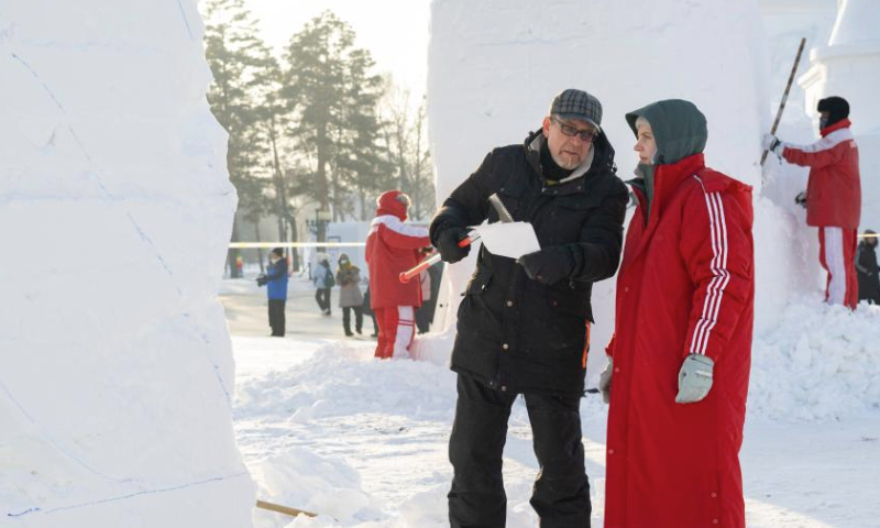 Contestants talk with each other while working on snow sculptures at the Sun Island International Snow Sculpture Art Expo park in Harbin, northeast China's Heilongjiang Province, Jan. 6, 2025. The 27th Harbin international snow sculpture competition kicked off on Monday, attracting snow sculptors of more than 20 teams from 10 countries. (Xinhua/Xie Jianfei)