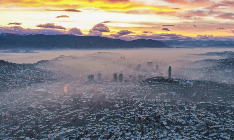 An aerial drone photo taken on Jan. 5, 2025 shows a winter view at sunset in Sarajevo, Bosnia and Herzegovina. Sarajevo is the capital and largest city of Bosnia and Herzegovina. Located in the east-central part of Bosnia and Herzegovina, it is situated in a hilly area, surrounded by mountains, with a population of about 300,000. (Xinhua/Yin Xiaosheng)