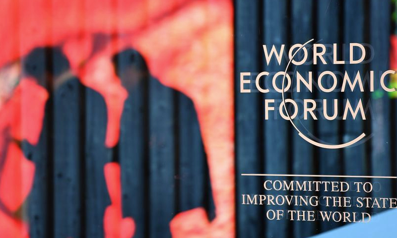 People walk past the logo of the World Economic Forum (WEF) in Davos, Switzerland, on Jan. 14, 2024. (Xinhua/Lian Yi)