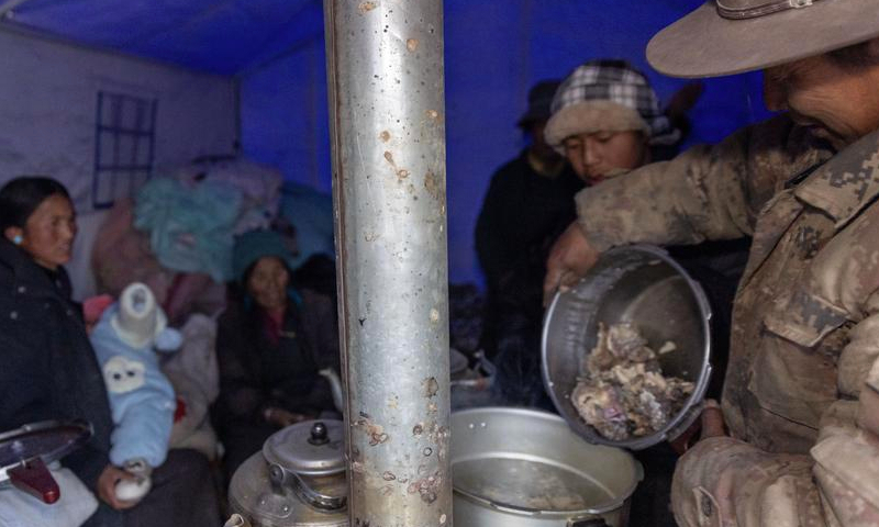 Earthquake-affected residents cook dinner in a tent at a village in Xigaze, southwest China's Xizang Autonomous Region, Jan. 7, 2025. (Xinhua/Jiang Fan)