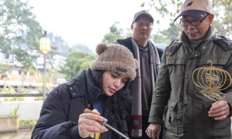 An international student tries to make sugar painting in Pianyan ancient town, Beibei District, southwest China's Chongqing Municipality, Jan. 7, 2025.

A group of international students attended a cultural event here on Tuesday to experience traditional Chinese culture. (Xinhua/Huang Wei)