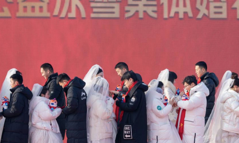 Loving couples exchange rings during a group wedding at the Harbin Ice-Snow World in Harbin, northeast China's Heilongjiang Province, Jan. 6, 2025. A free group wedding which is part of the Harbin International Ice and Snow Festival was held at the Harbin Ice-Snow World on Monday. The winter-themed event was participated by 43 couples from 17 provinces, municipalities or regions in China. (Xinhua/Zhang Tao)