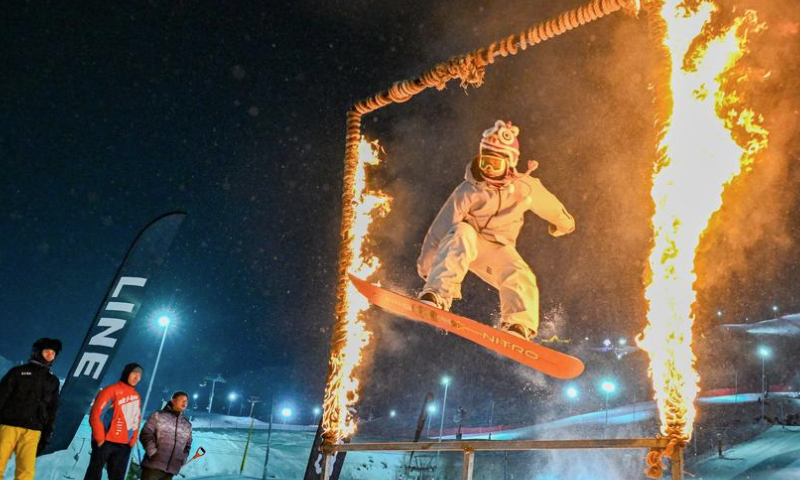 A tourist skis through flames at Jiangjunshan International Ski Resort in Altay, northwest China's Xinjiang Uygur Autonomous Region, Jan. 29, 2025. (Xinhua/Chen Shuo)