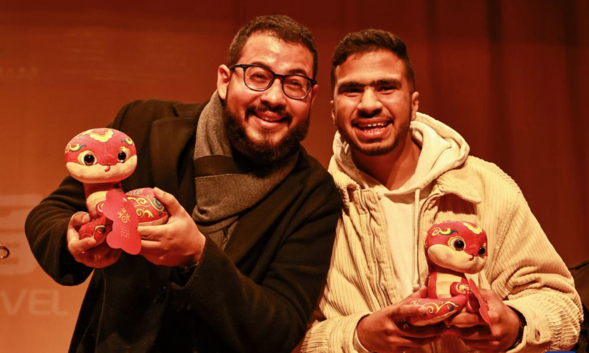 Moroccan spectators pose for a photo with plush snake toys during a concert to celebrate the upcoming Chinese Spring Festival in Rabat, Morocco, Jan. 15, 2025. (Xinhua/Huo Jing)