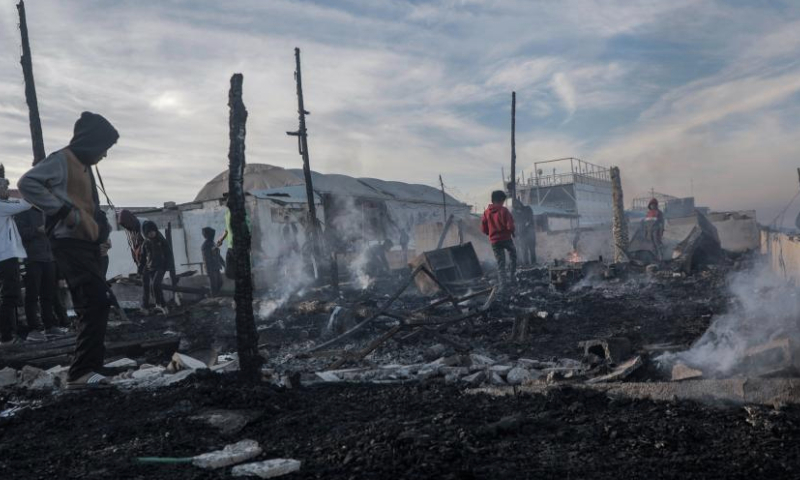 Palestinians are seen at the site of destroyed tents after an Israeli bombardment, in Deir al-Balah city in the central Gaza Strip, on Jan. 14, 2025. (Photo by Rizek Abdeljawad/Xinhua)