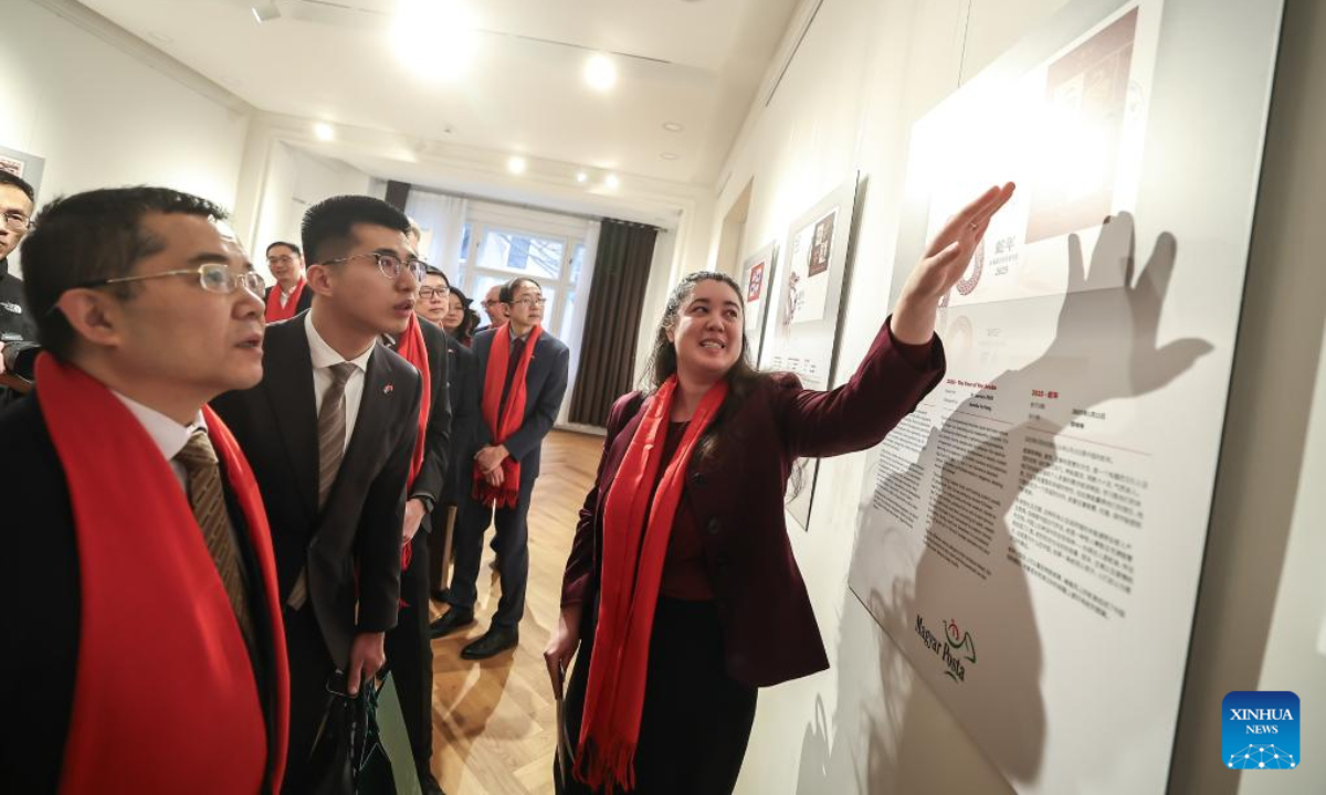 Hu-Yang Kamilla (R), designer of the Year of the Snake stamp issued by the Hungarian Post, introduces her works during a launch ceremony in Budapest, Hungary, on Jan. 21, 2025. A commemorative sheet of postage stamps celebrating the upcoming Chinese Lunar New Year, the Year of the Snake, was unveiled on Tuesday at the China Cultural Center in Budapest, Hungary. (Photo by David Balogh/Xinhua)