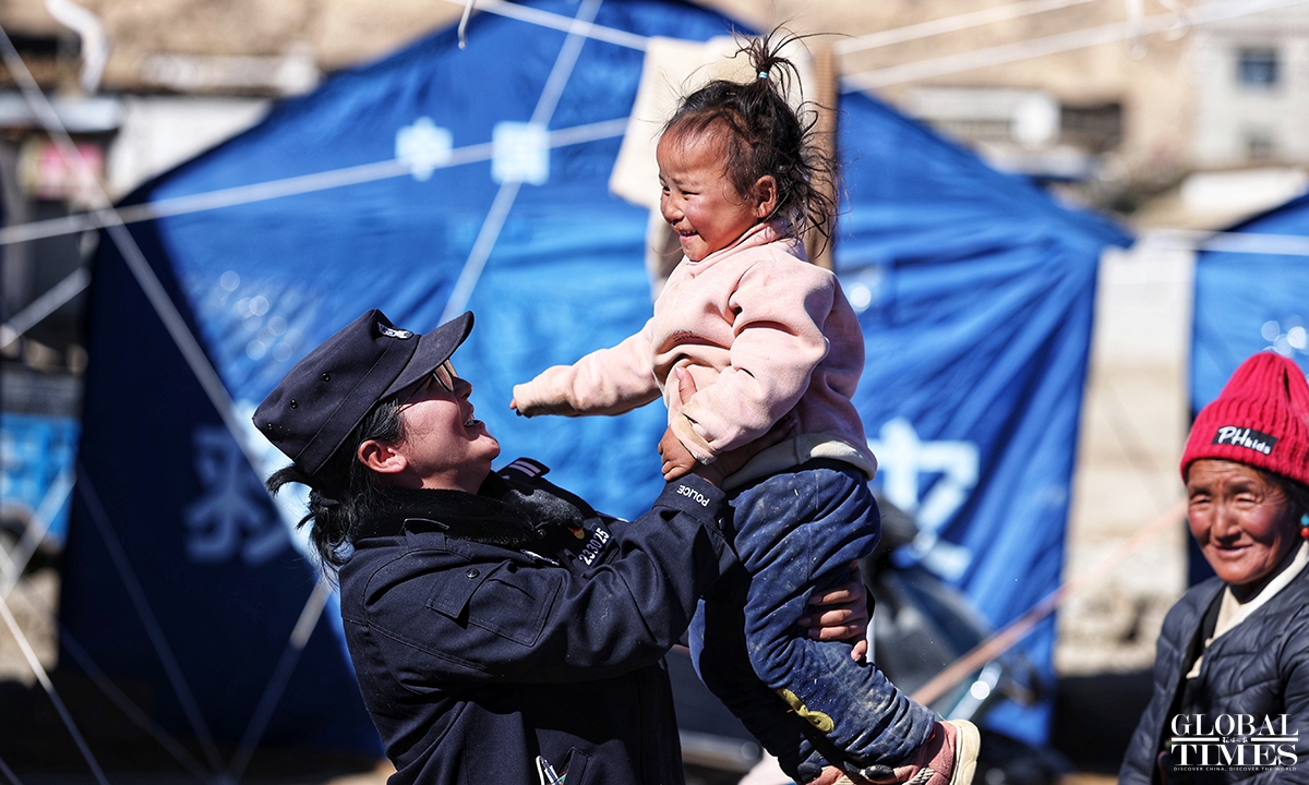 A female police officer is taking care of a child affected by the earthquake at the epicenter Tsogo Township of Dingri County in Southwest China's Xizang Autonomous Region on January 9, 2025. Photo: Cui Meng/GT