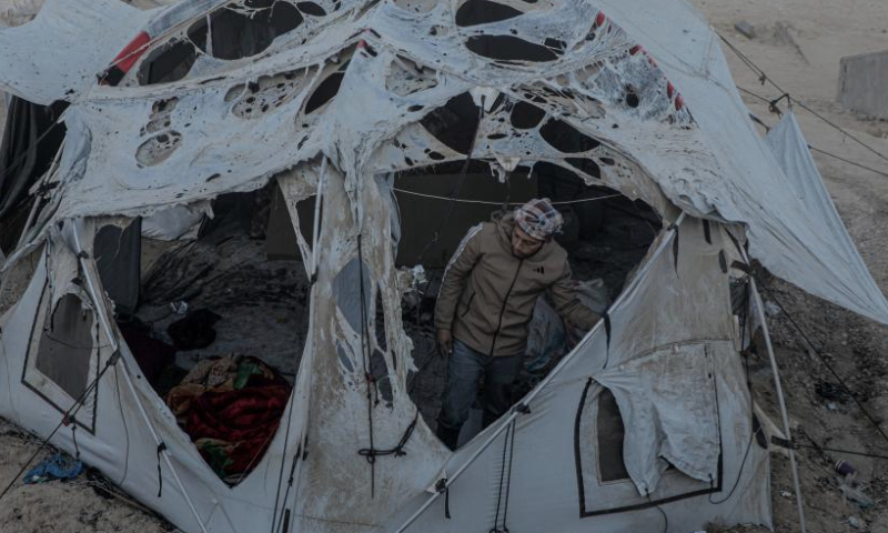 A Palestinian checks a destroyed tent after an Israeli bombardment, in Deir al-Balah city in the central Gaza Strip, on Jan. 14, 2025. (Photo by Rizek Abdeljawad/Xinhua)