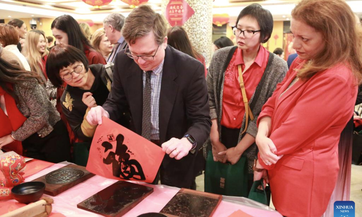 A guest tries rubbing the character Fu during the 2025 Spring Festival reception at the Chinese Consulate General in New York, on Jan. 23, 2025. (Xinhua/Liu Yanan)