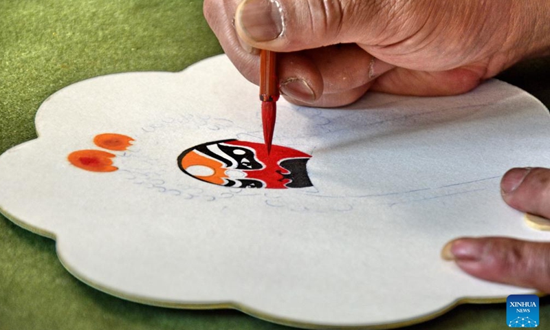 Yang Qiang paints Peking Opera facial makeup at a cultural center in Shijingshan District in Beijing, capital of China, Jan. 8, 2025. (Xinhua/Li Xin)