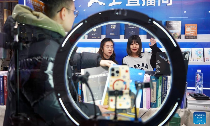 Staff members promote books via live streaming during the 2025 Beijing Book Fair in Beijing, capital of China, Jan. 9, 2025. The 2025 Beijing Book Fair opened on Thursday at the China International Exhibition Center, with over 400,000 titles on display, according to the organizers. (Xinhua/Pan Xu)