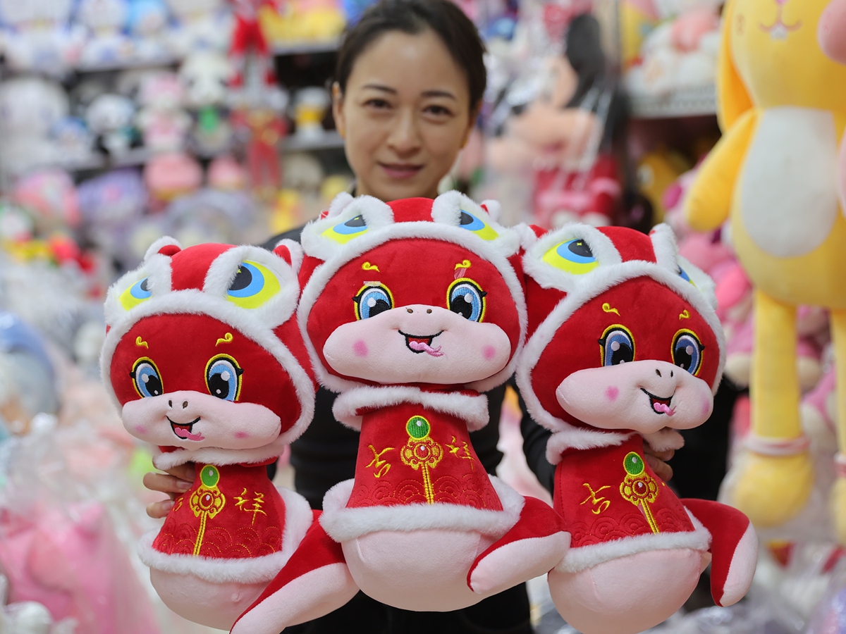 A woman showcases snake plush toys in Qinhuangdao, North China's Hebei Province. Photo: IC