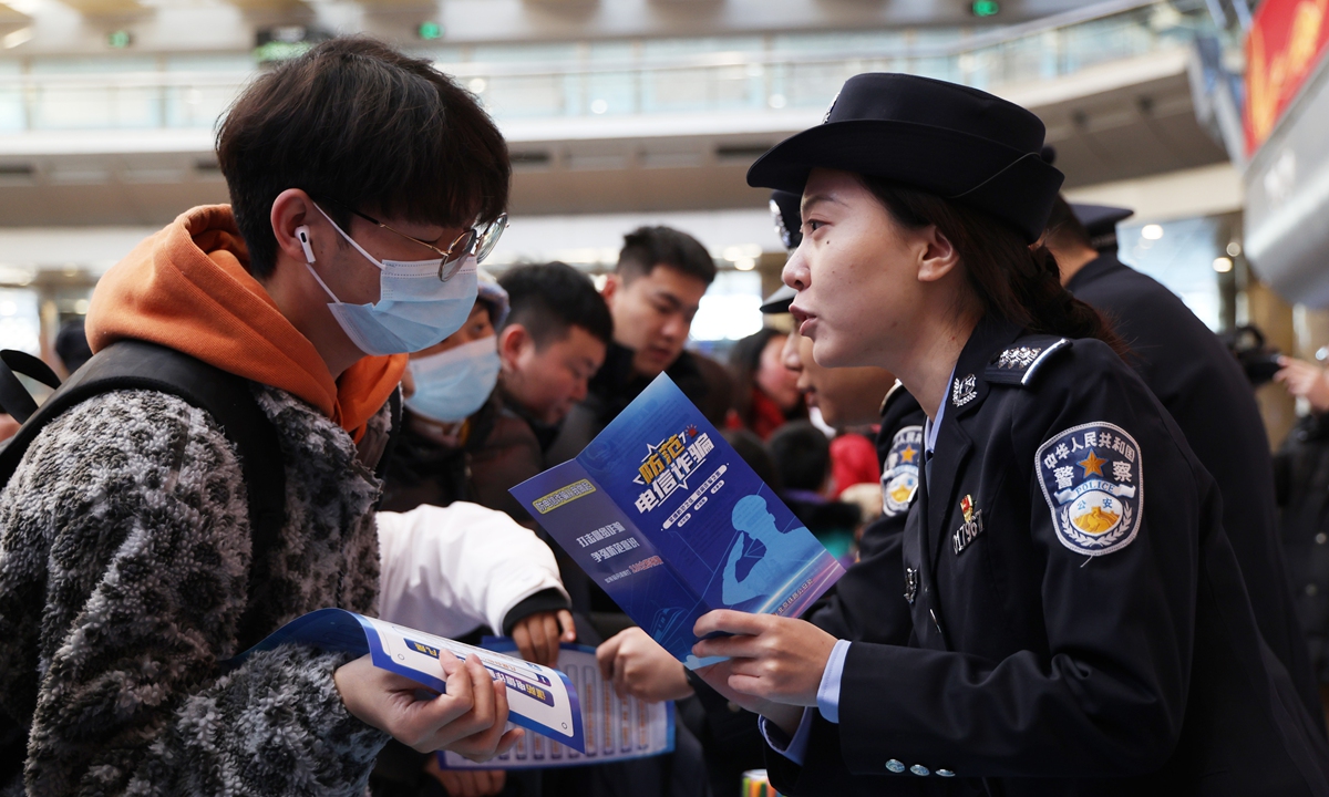 A police officer disseminates anti-telecom fraud information to passengers at the Beijing West Railway Station, on January 14, 2025. Photo: IC