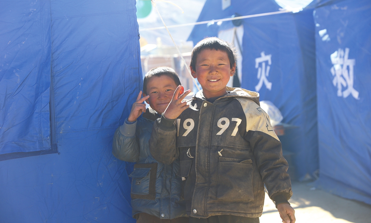 Children smile to the camera in front of disaster-relief tents after the 6.8-magnitude earthquake hit Dingri county, Xigaze, Southwest China's Xizang Autonomous Region on January 8, 2025. Photo: VCG