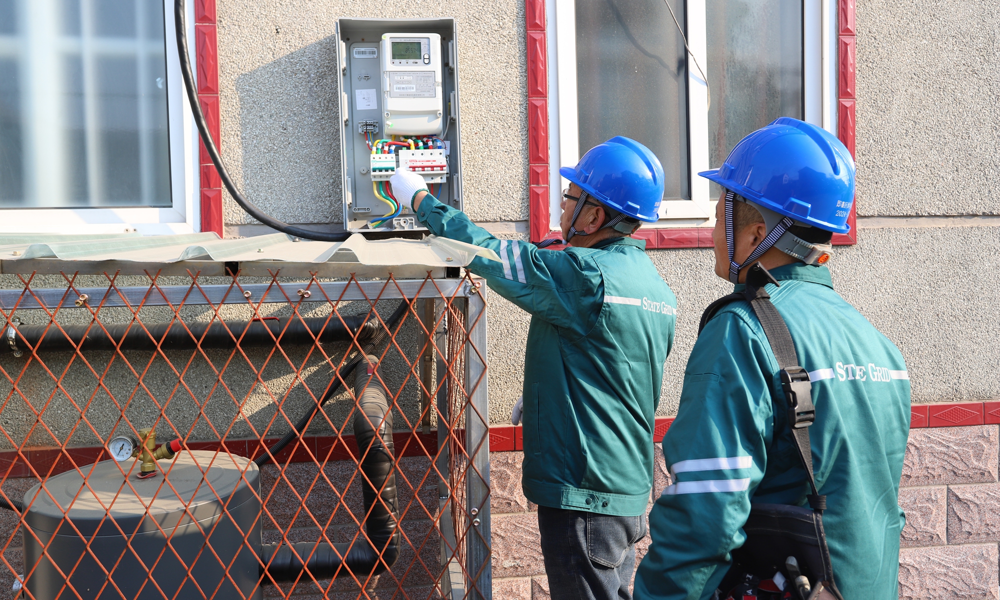 Employees of the State Grid Qingdao Power Supply Company help electric heating customers check for potential electrical safety hazards.