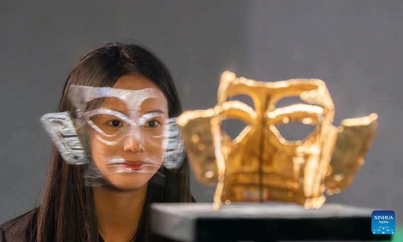 A visitor looks at a golden mask on display in the new building of Sanxingdui Museum in Guanghan City, southwest China's Sichuan Province, Dec. 18, 2024.