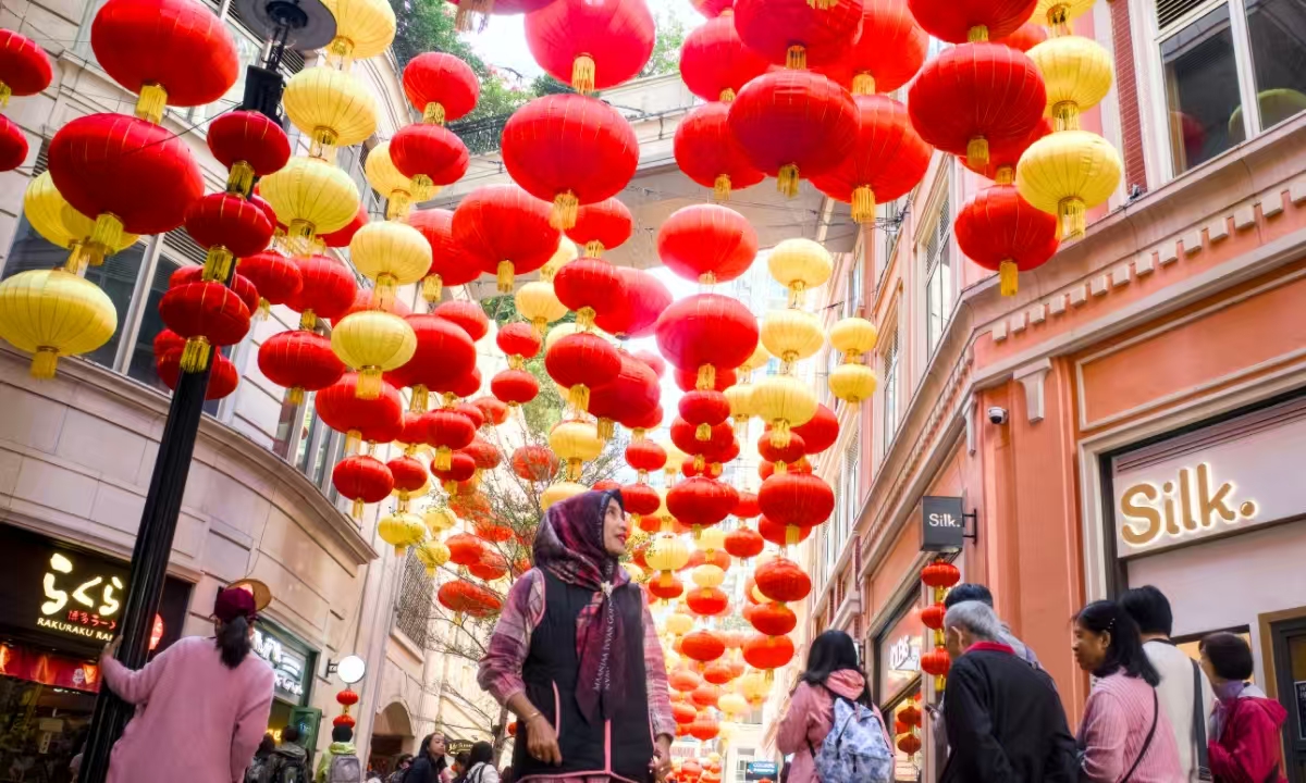 On January 19, 2025, in Hong Kong's Wan Chai district, Lee Tung Avenue is filled with festive Chinese New Year vibes. Traditional Chinese lanterns adorned the sky, glowing brightly under the sunlight, attracting numerous visitors and locals to stop and enjoy the atmosphere. Photo: VCG