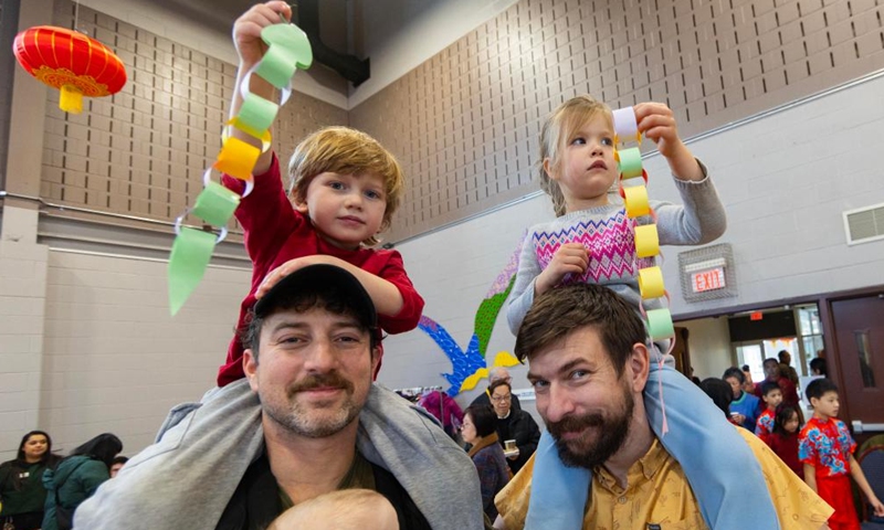 Children sitting on their fathers' shoulders display handmade paper snakes in celebration of the upcoming Spring Festival, or the Chinese Lunar New Year, at the Chinese Cultural Center of Greater Toronto in Toronto, Canada, Jan. 26, 2025. (Photo by Zou Zheng/Xinhua)