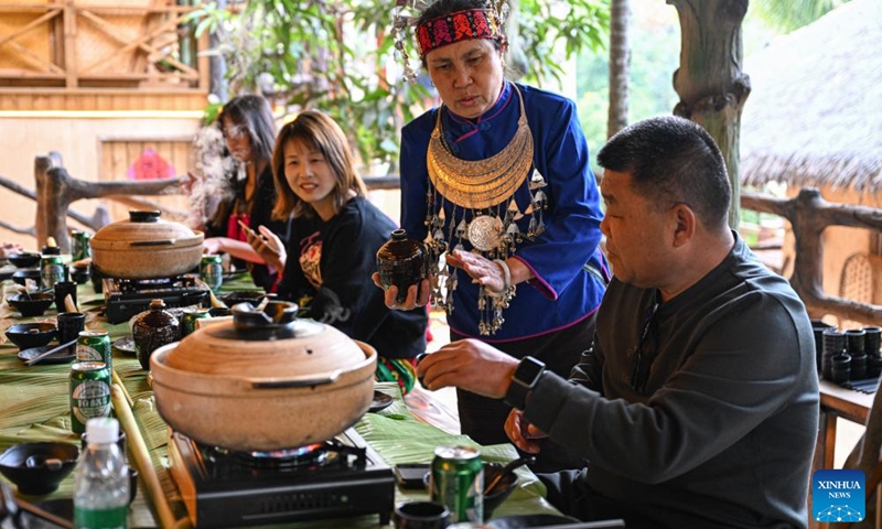 A villager serves traditional rice wine of Li ethnic group at Binglanggu tourism area in Baoting Li and Miao Autonomous County, south China's Hainan Province, Jan. 28, 2025. An event featuring Li ethnic group culture was held at Binglanggu tourism area to celebrate the Chinese New Year, where tourists could dress in traditional Li attire and taste food with Li characteristics. Photo: Xinhua