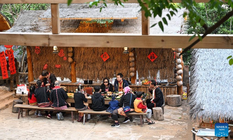 Tourists enjoy a traditional family reunion dinner of Li ethnic group at Binglanggu tourism area in Baoting Li and Miao Autonomous County, south China's Hainan Province, Jan. 28, 2025. An event featuring Li ethnic group culture was held at Binglanggu tourism area to celebrate the Chinese New Year, where tourists could dress in traditional Li attire and taste food with Li characteristics. Photo: Xinhua