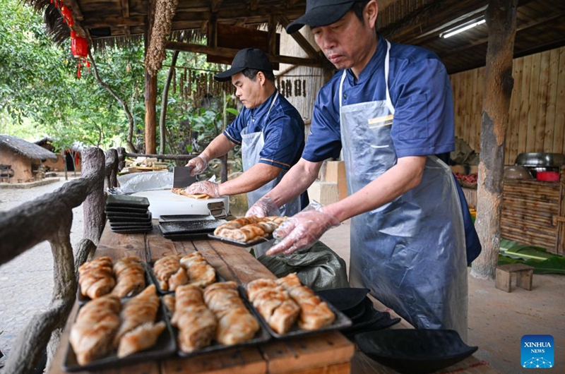 Villagers prepare rolls made from sticky rice and coconuts at Binglanggu tourism area in Baoting Li and Miao Autonomous County, south China's Hainan Province, Jan. 28, 2025. An event featuring Li ethnic group culture was held at Binglanggu tourism area to celebrate the Chinese New Year, where tourists could dress in traditional Li attire and taste food with Li characteristics. Photo: Xinhua