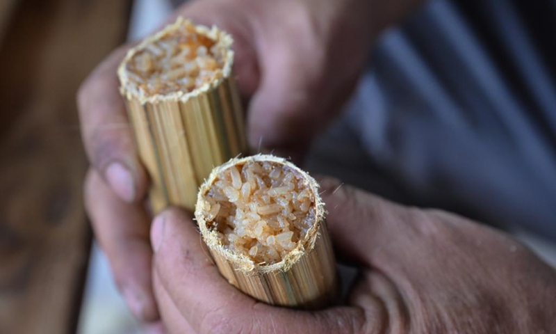 A villager shows sticky rice food in bamboo tubes at Binglanggu tourism area in Baoting Li and Miao Autonomous County, south China's Hainan Province, Jan. 28, 2025. An event featuring Li ethnic group culture was held at Binglanggu tourism area to celebrate the Chinese New Year, where tourists could dress in traditional Li attire and taste food with Li characteristics. Photo: Xinhua