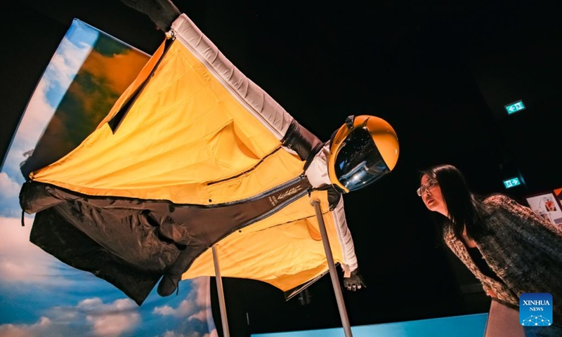 A woman looks at a wingsuit used for gliding sports during a media preview of the Extreme Sports: Beyond Human Limits exhibition in Vancouver, British Columbia, Canada, on Jan. 30, 2025. Showcasing some of the most extreme sports in the world, including mountain climbing, skydiving, and deep-sea diving, the exhibition runs from Jan. 31 to May 19, 2025. Photo: Xinhua