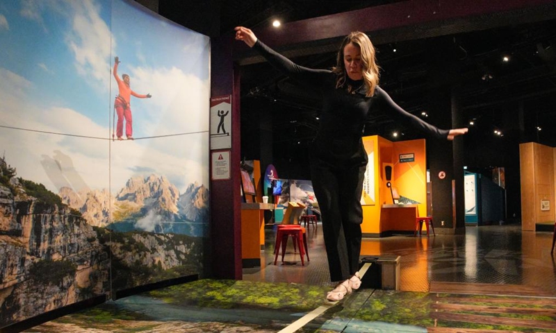 A woman tries out slacklining during a media preview of the Extreme Sports: Beyond Human Limits exhibition in Vancouver, British Columbia, Canada, on Jan. 30, 2025. Showcasing some of the most extreme sports in the world, including mountain climbing, skydiving, and deep-sea diving, the exhibition runs from Jan. 31 to May 19, 2025. Photo: Xinhua