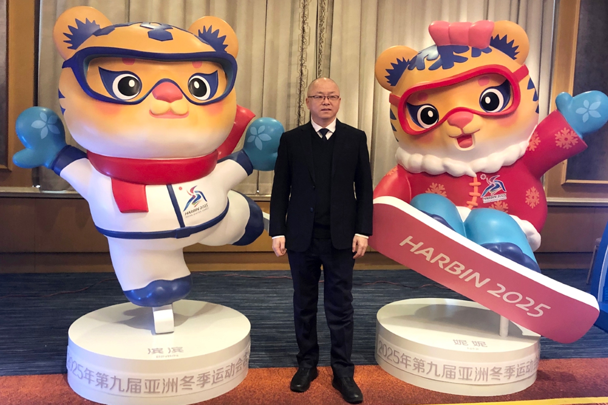 Chen Lei, head of the mascots and emblem design team for the 9th Asian Winter Games in Harbin, poses for photos with the mascots.
Photo: Courtesy of Chen Lei