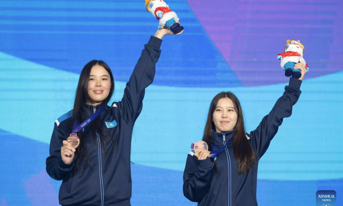 Bronze medalists Ardana Makhanova (L)/Ayana Zholdas of Kazakhstan react during the awarding ceremony for the freestyle skiing women's aerials synchro final at the 9th Asian Winter Games in Yabuli, northeast China's Heilongjiang Province, Feb. 11, 2025. (Xinhua/Xie Jianfei)