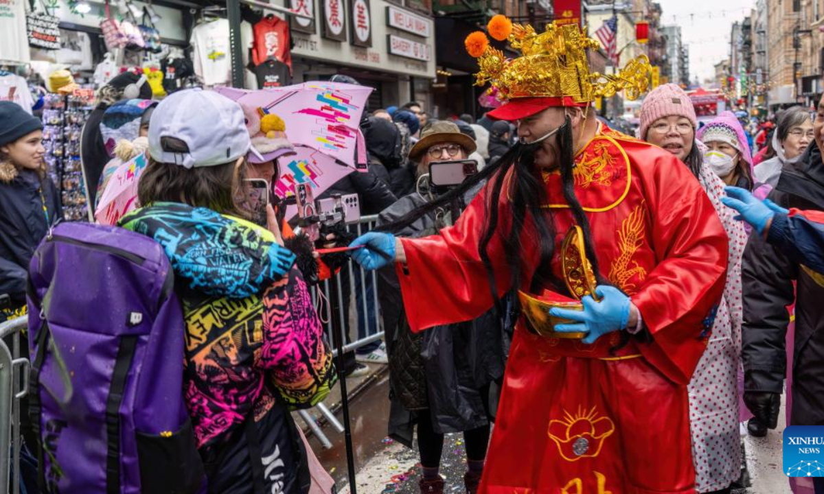 A participant dressed as a God of Wealth hands out red envelopes that symbolize wealth during the Lunar New Year parade in New York City, the United States, Feb. 16, 2025.

The 27th Lunar New Year parade and festival returned to Chinatown in Lower Manhattan, New York City, on Sunday despite unusual downpours.

The rain didn't dampen the high spirits of the celebration's participants, who enjoyed a display of floats, bands and performances like dragon and lion dances. Thousands of people from far and near lined up the streets in Chinatown, and they also had a chance to patronize booths and restaurants in the area. (Photo by Winston Zhou/Xinhua)