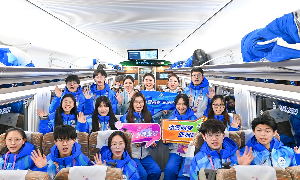 Volunteers for the Harbin Asian Winter Games pose for a photo with service personnel on their returning train on February 12, 2025. Photo: VCG