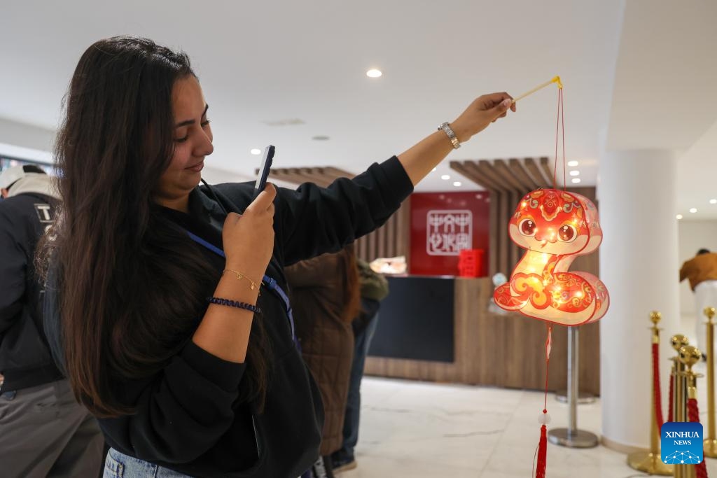 A Moroccan woman takes photos of a snake-shaped lantern at a Lantern Festival celebration event in Rabat, Morocco, on Feb. 12, 2025. (Photo: Xinhua)