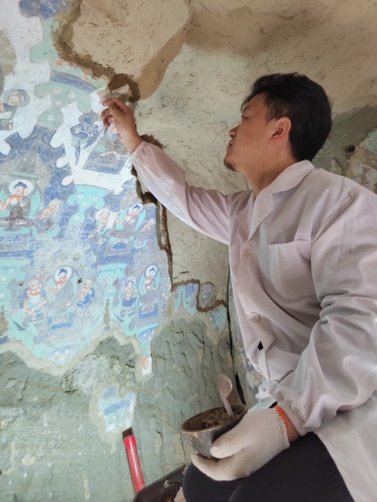 An expert conducts restoration work on the murals at the Kizil caves in Northwest China's Xinjiang Uygur Autonomous Region. Photo: Courtesy of the Kizil Caves Research Institute