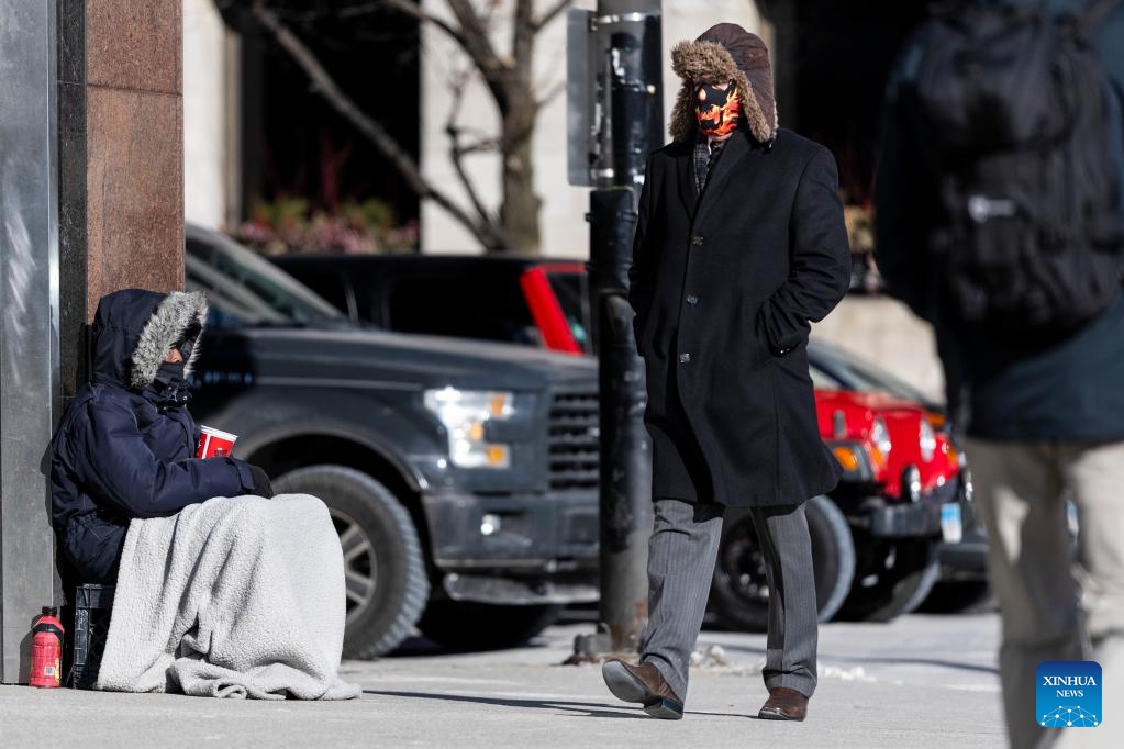 A man covered almost completely from head-to-toe walks along a street in Chicago, the United States, on Feb. 18, 2025. (Photo: Xinhua)