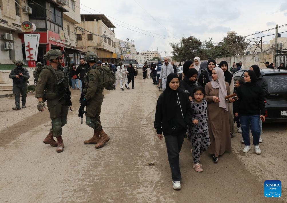 Israeli soldiers prevent displaced Palestinians in the West Bank city of Jenin from getting back to their houses in the Jenin refugee camp, on Feb. 19, 2025. Palestine on Wednesday accused Israel of waging a comprehensive war on the West Bank, particularly in the northern regions, involving crimes of murder, displacement, and the destruction of property. (Photo: Xinhua)