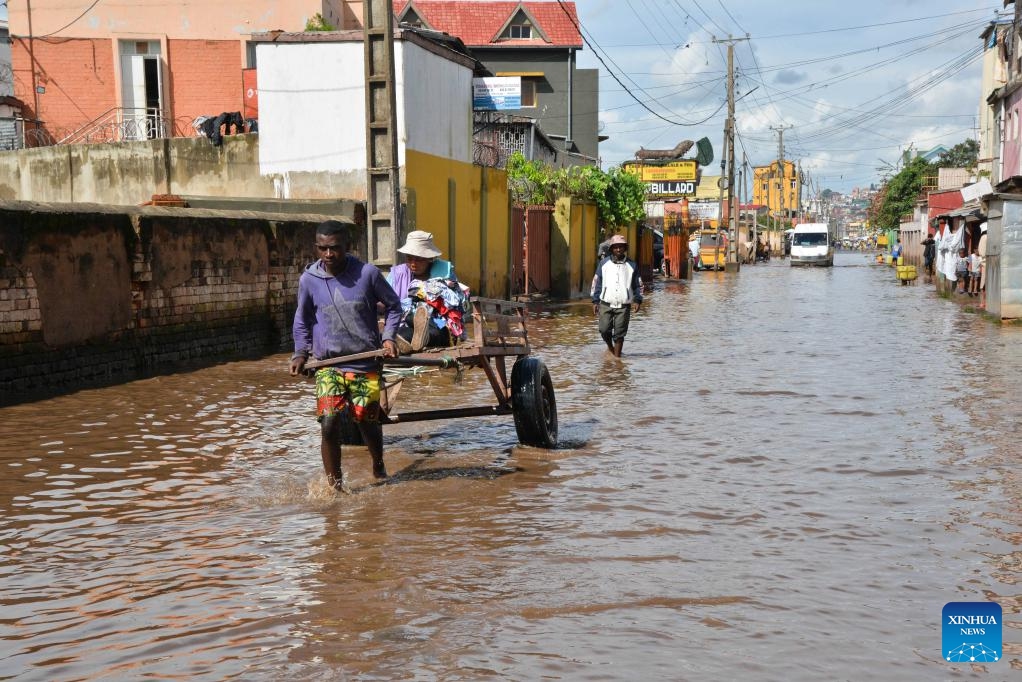 Residents move through a flooded road in Antananarivo, Madagascar, Feb. 20, 2025. The death toll from the heavy rains that have hit Madagascar since Feb. 14 rose to 11, according to the latest report from the National Office for Risk and Disaster Management (BNGRC) released on Thursday. (Photo: Xinhua)